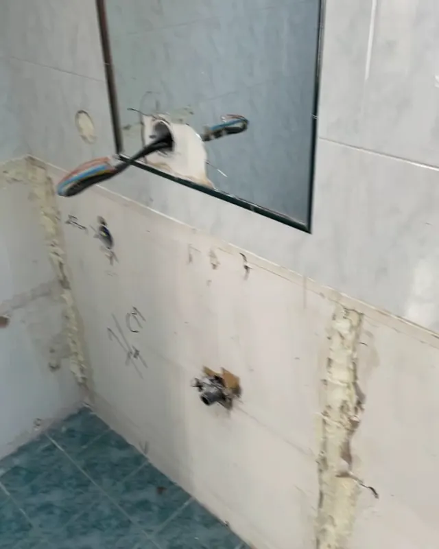Mur de salle de bain avec arrivées d'eau en attente, carrelage ancien déposé